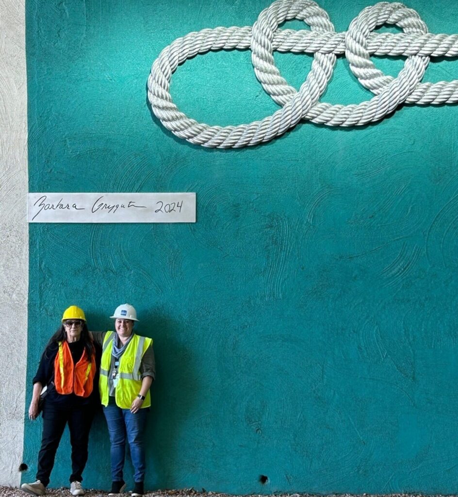 Barbara Grygutis and Tanya Galin standing beneath the completed installation.