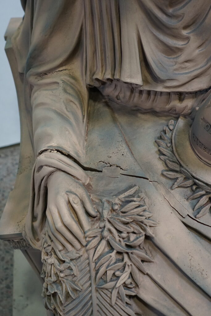 Close up of damages to the figure’s arm.