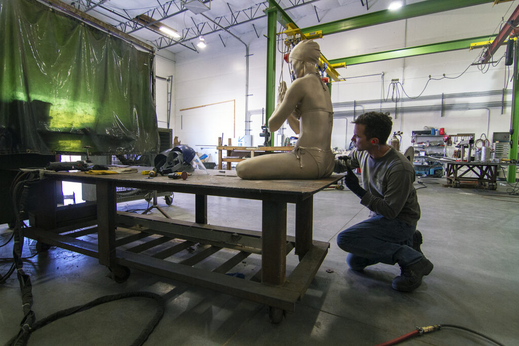 James working on chasing one of Carole Feuerman’s Diver Figures - the sculpture is in raw bronze, and depicts a female swimmer sitting cross legged